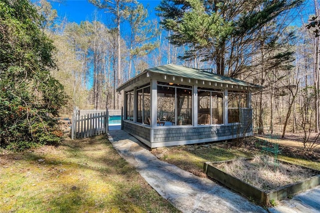 view of front facade featuring fence and a sunroom