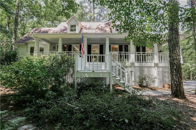 new england style home with stairs and a porch