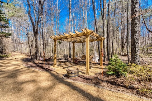 view of yard featuring a wooded view and a pergola