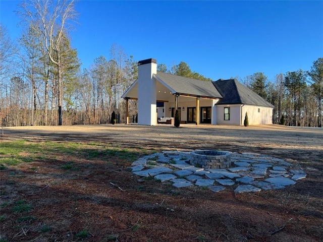 exterior space featuring an outdoor fire pit and a chimney