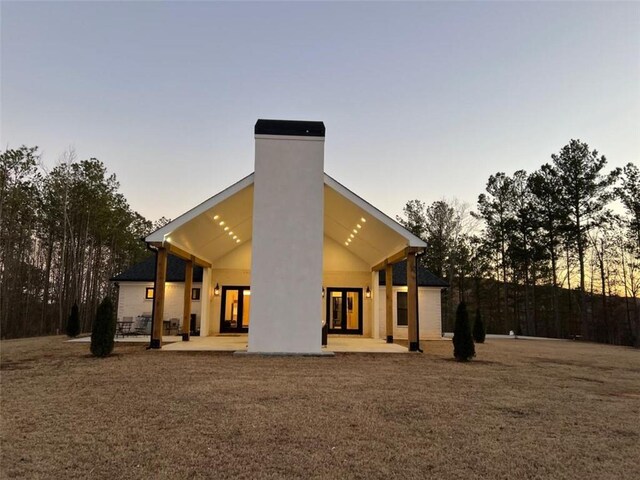 back of house with a patio area and a chimney