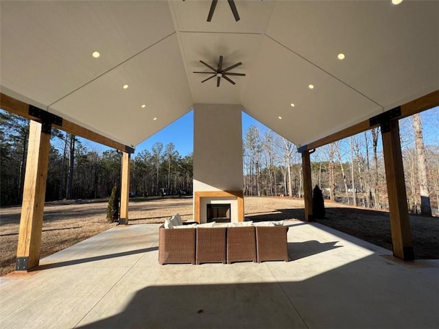 view of patio featuring an outdoor living space with a fireplace and a ceiling fan