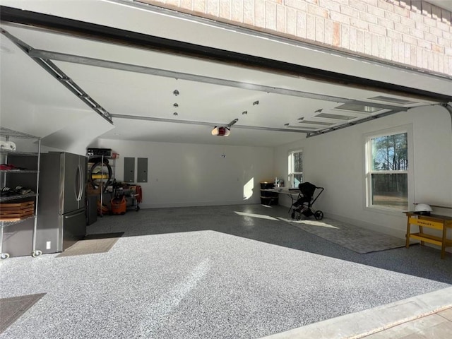 garage featuring baseboards, electric panel, freestanding refrigerator, and a garage door opener