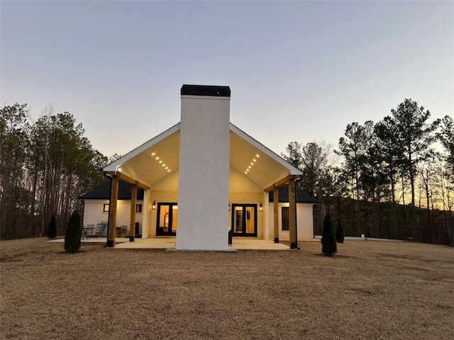 613 Bill Rutledge Rd, Winder, GA 30680 - back of property at dusk featuring french doors, a patio, and a chimney