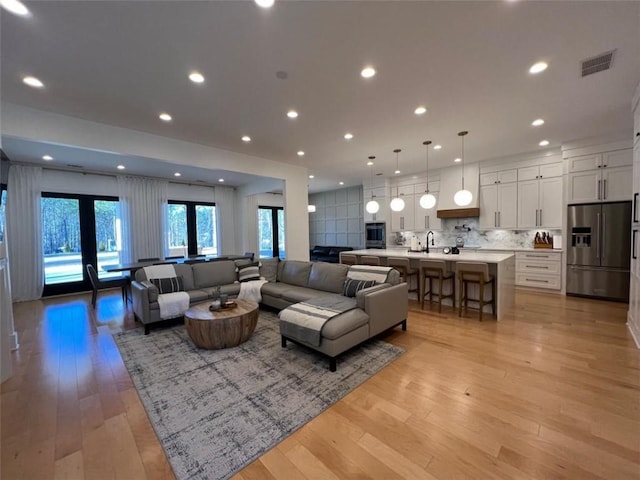 living room featuring french doors, recessed lighting, visible vents, and light wood-style floors
