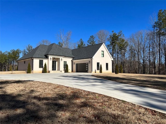 exterior space featuring an attached garage, concrete driveway, and stucco siding