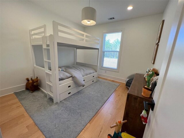 bedroom featuring baseboards, wood finished floors, and recessed lighting