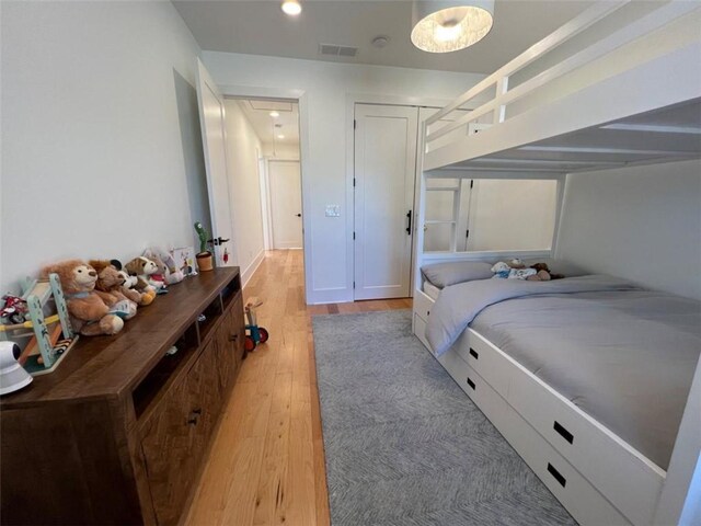 bedroom with light wood finished floors, attic access, visible vents, and recessed lighting