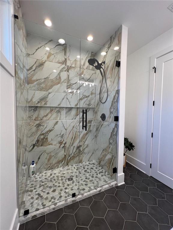 full bath featuring baseboards, a marble finish shower, visible vents, and recessed lighting