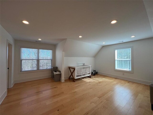 additional living space with lofted ceiling, recessed lighting, baseboards, and light wood-style floors