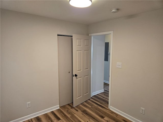 spare room featuring wood finished floors and baseboards