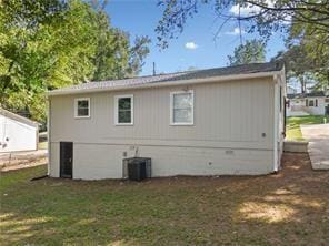 back of property with central air condition unit and a lawn