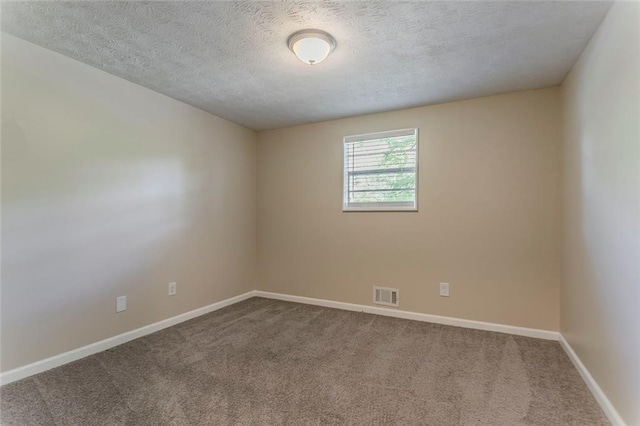 carpeted empty room with a textured ceiling and baseboards