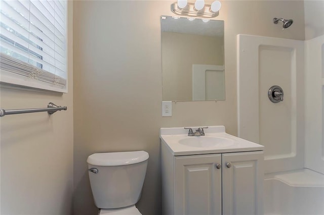 bathroom featuring vanity, toilet, and a shower