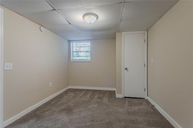 spare room featuring carpet floors, a paneled ceiling, baseboards, and a smoke detector