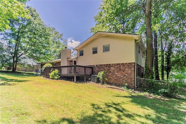 rear view of house featuring brick siding, a deck, and central AC