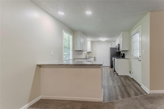 kitchen featuring plenty of natural light, white cabinetry, a sink, recessed lighting, and a textured ceiling