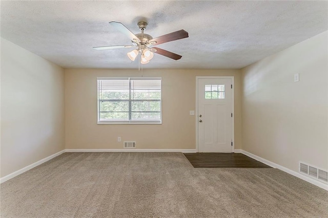 entrance foyer featuring ceiling fan, carpet floors, a textured ceiling, and baseboards