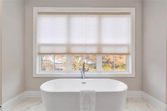 bathroom featuring a bathing tub and a wealth of natural light