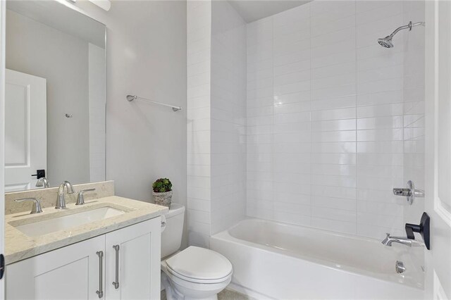 full bathroom featuring tiled shower / bath combo, toilet, and vanity