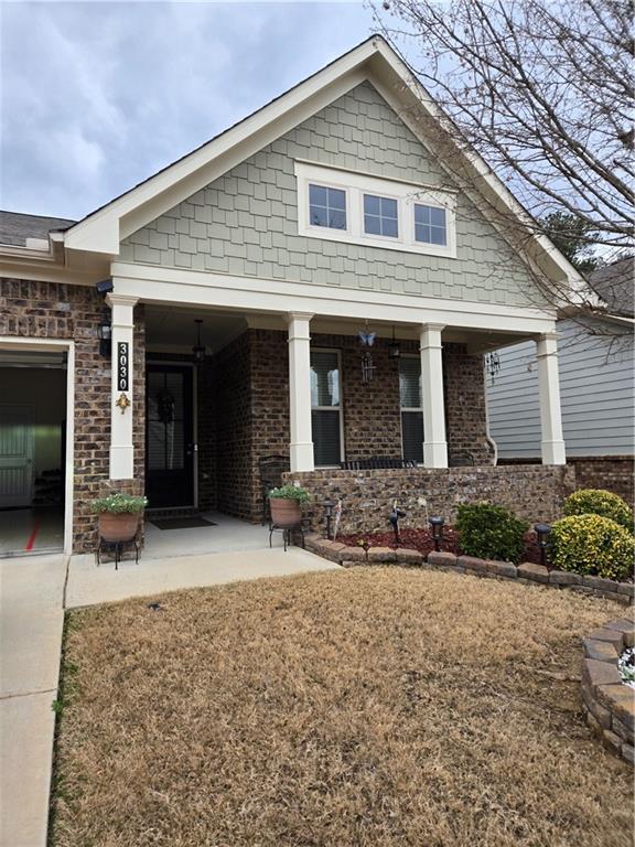 craftsman house featuring a porch and brick siding