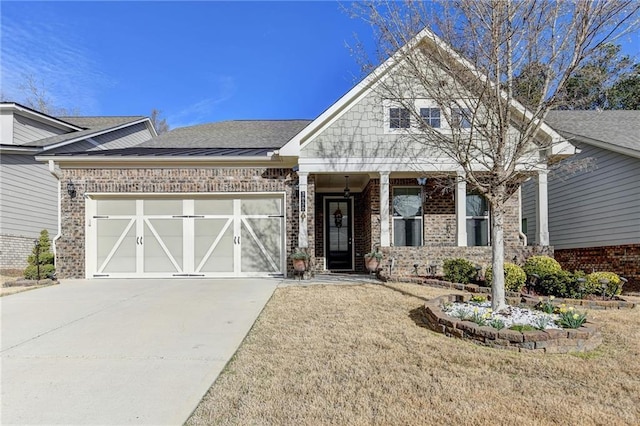 craftsman inspired home with concrete driveway, an attached garage, and brick siding