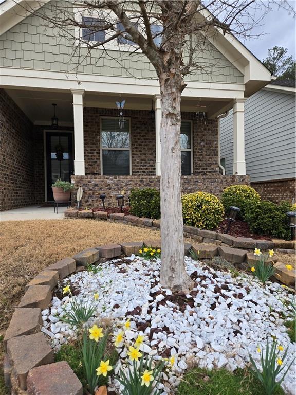 view of exterior entry featuring covered porch and brick siding