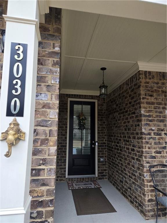 doorway to property with brick siding