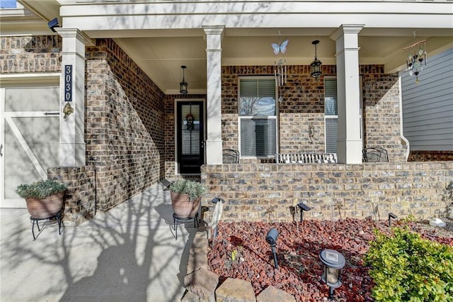 property entrance with brick siding and covered porch