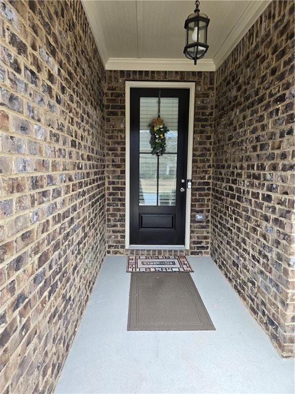 view of exterior entry featuring brick siding