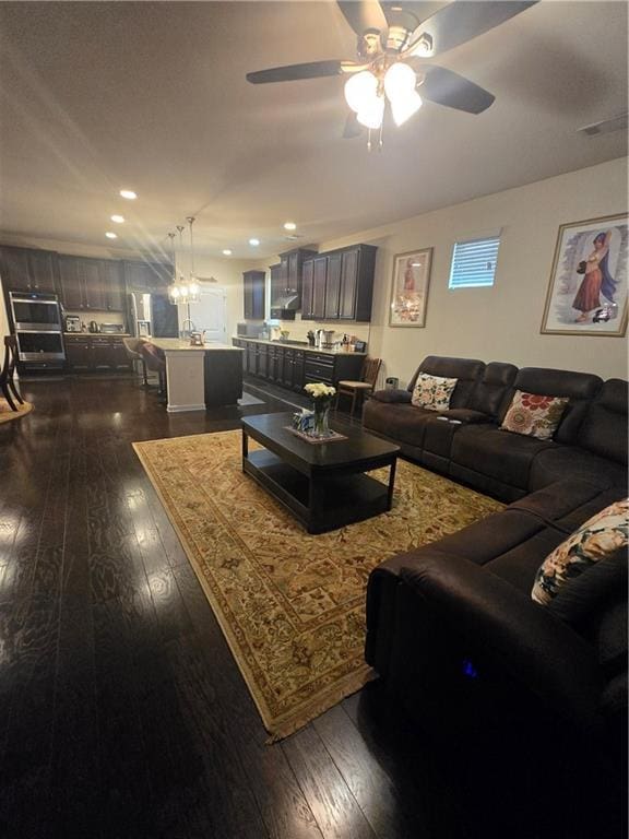 living area with dark wood-style floors and ceiling fan