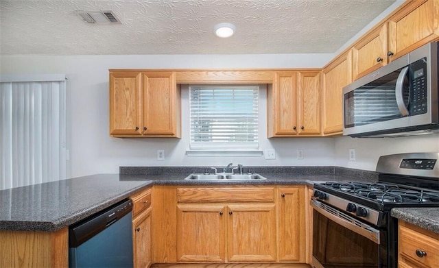 2960 Fields Dr, Lithonia, GA 30038 - kitchen with stainless steel appliances, a sink, a peninsula, and a textured ceiling