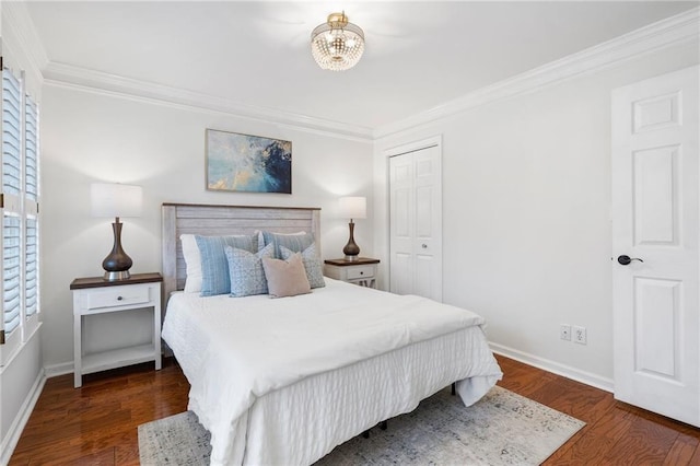 bedroom with a closet, ornamental molding, dark hardwood / wood-style floors, and a chandelier