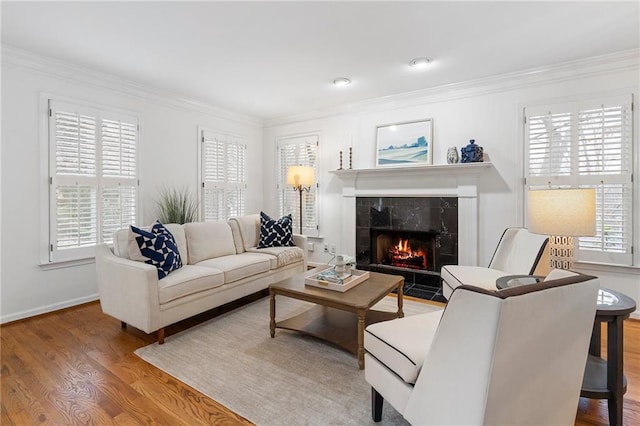 living room featuring hardwood / wood-style flooring, plenty of natural light, a fireplace, and crown molding