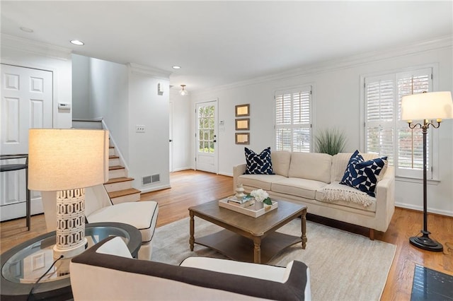 living room with ornamental molding and light hardwood / wood-style flooring