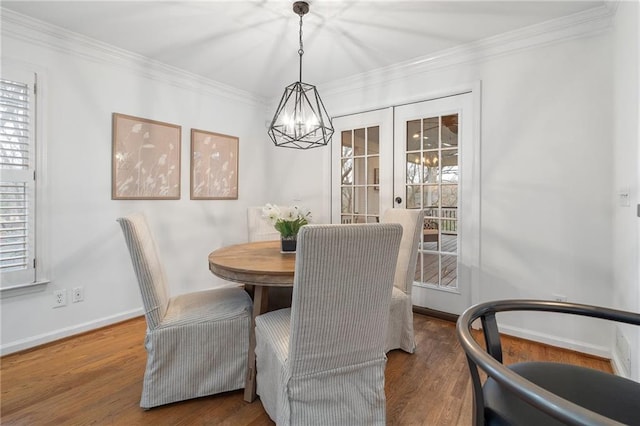 dining room with crown molding, hardwood / wood-style floors, and french doors