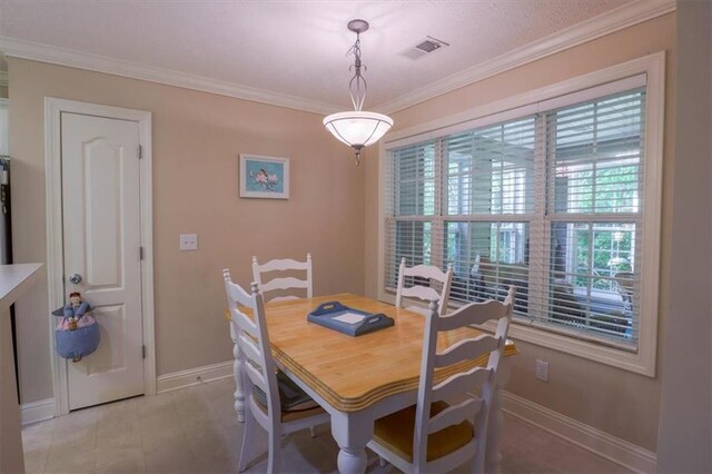 dining room featuring baseboards, visible vents, and crown molding