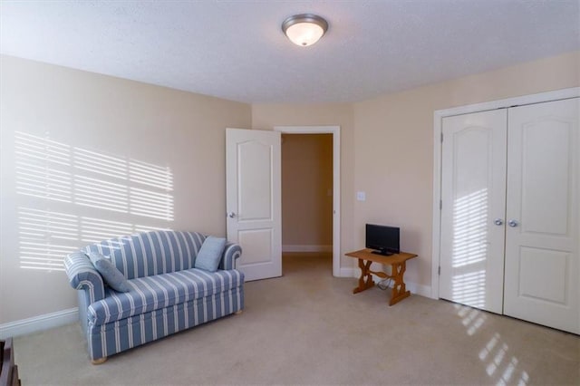 sitting room with a wealth of natural light, carpet floors, and baseboards