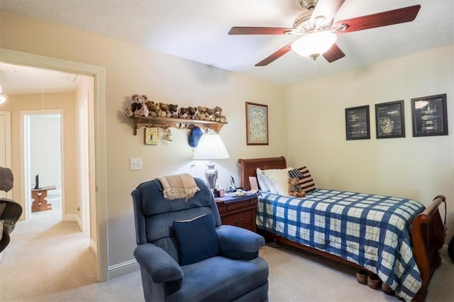 carpeted bedroom featuring attic access, a ceiling fan, and baseboards