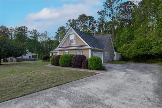 view of home's exterior with driveway, board and batten siding, an attached garage, fence, and a yard