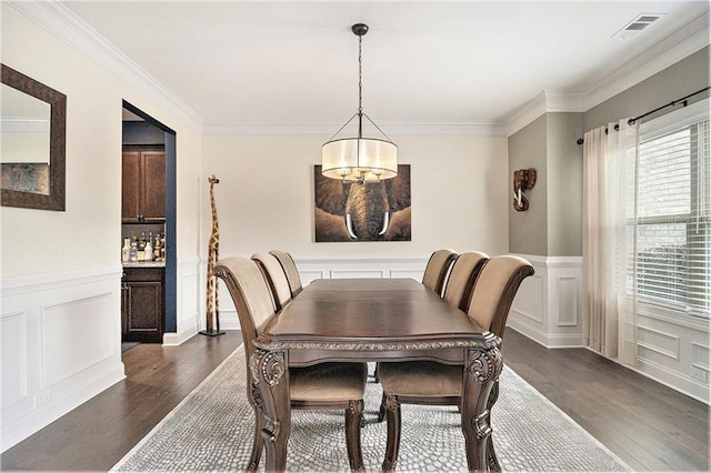 dining area with crown molding and dark wood-type flooring