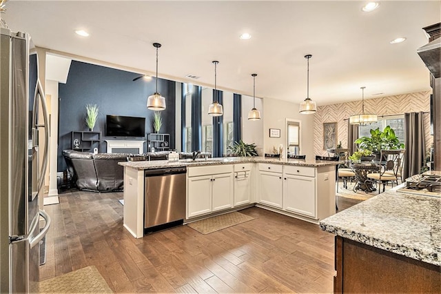 kitchen featuring pendant lighting, white cabinetry, and appliances with stainless steel finishes