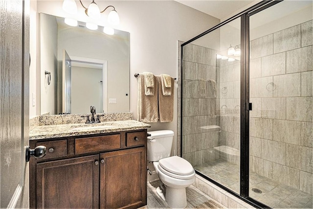 bathroom featuring vanity, an enclosed shower, and toilet