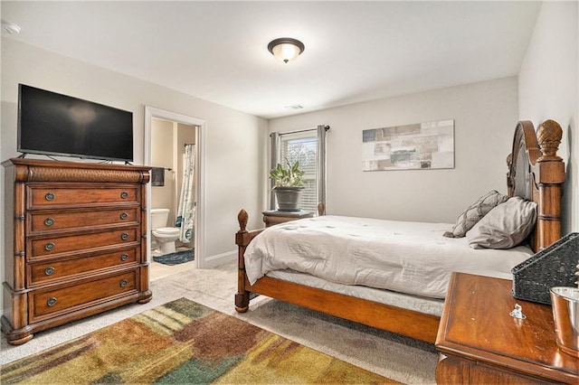 bedroom with carpet floors and connected bathroom