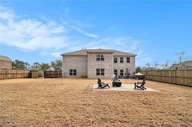 back of property with an outdoor fire pit, a yard, and a patio area