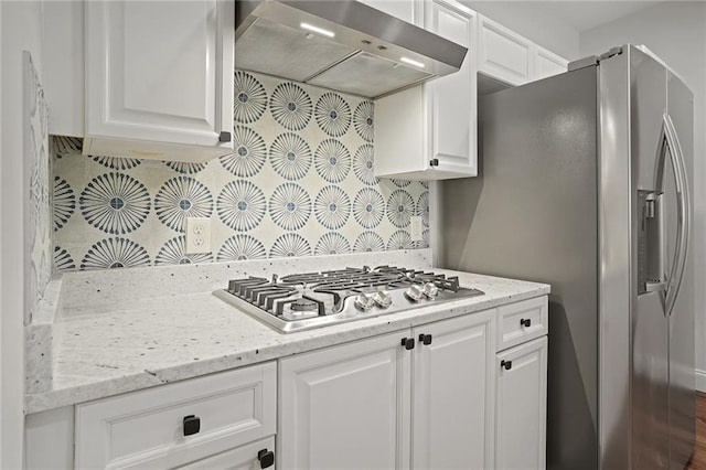 kitchen featuring backsplash, white cabinetry, stainless steel appliances, and extractor fan