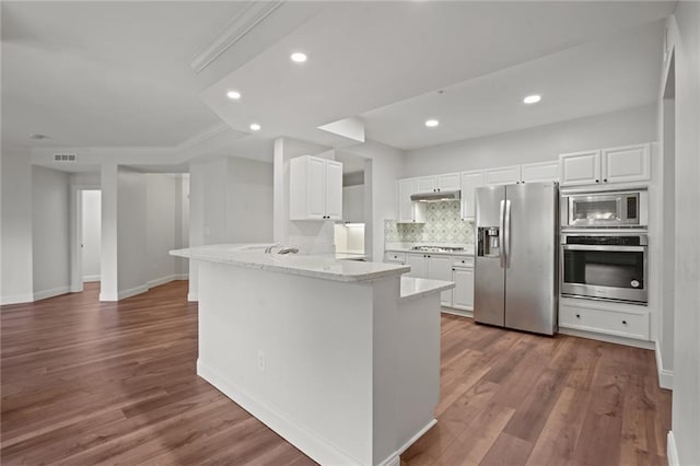 kitchen with white cabinetry, appliances with stainless steel finishes, light hardwood / wood-style floors, light stone counters, and kitchen peninsula