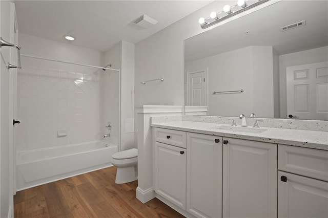 full bathroom featuring hardwood / wood-style floors, vanity, toilet, and shower / washtub combination