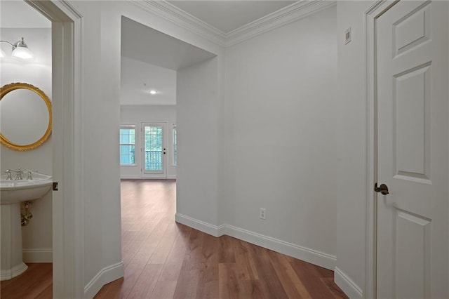 hallway featuring wood-type flooring and ornamental molding