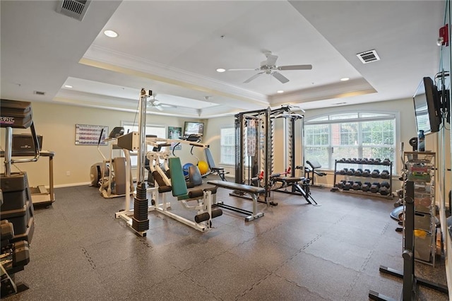 gym with a tray ceiling, ceiling fan, and crown molding